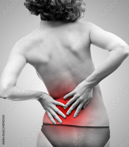 Photo: Femme se tenant le dos à cause de la douleur Femme se tenant le dos à cause de la douleur