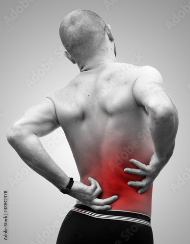 Photo: Homme se tenant le dos à cause de la douleur Homme se tenant le dos à cause de la douleur