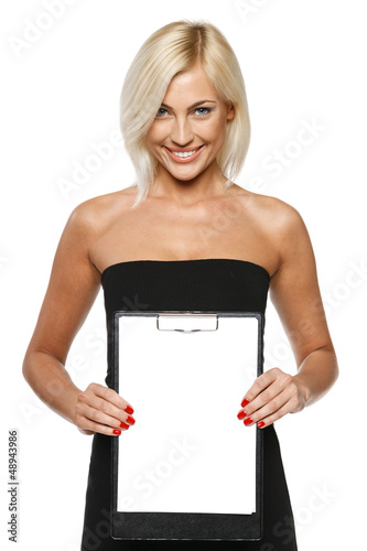 Photo: Smiling woman standing showing white paper clipboard Smiling woman standing showing white paper clipboard