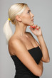 Side view of beautiful blond pensive woman with hand on chin