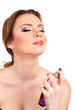 Young woman applying perfume isolated on white