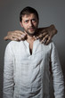 Young bearded man choked by two huge hands