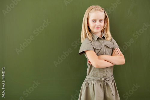 Photo: Scoolgirl standing near blackboard Scoolgirl standing near blackboard