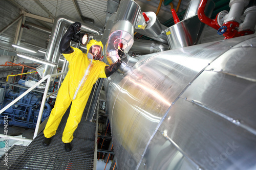 Photo: Technician in yellow uniform checking technological system Technician in yellow uniform checking technological system