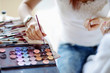 Woman's hand upon set of eyeshadows