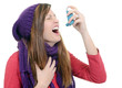 Woman with asthma using an asthma inhaler