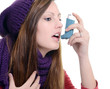 Woman with asthma using an asthma inhaler