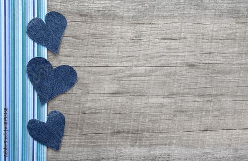 Photo: Holzhintergrund mit drei Herzen aus Jeansstoff Holzhintergrund mit drei Herzen aus Jeansstoff