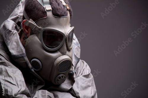 Photo: Man in protective mask on gray background Man in protective mask on gray background