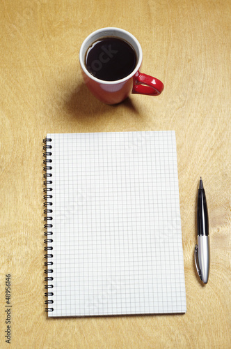 Photo: Notepad and cup of coffee Notepad and cup of coffee