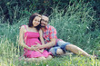 Couple future parents relaxing on grass.