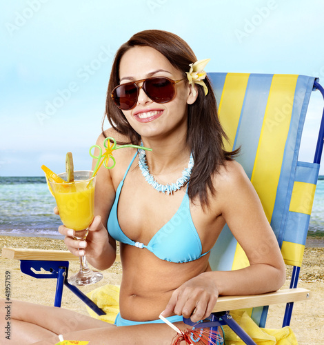 Photo: Girl in bikini on beach drinking cocktail. Girl in bikini on beach drinking cocktail.