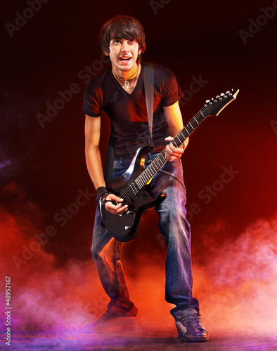 Photo: Man playing guitar. Man playing guitar.