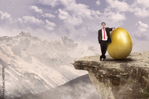 Photo: Successful businessman and gold egg Successful businessman and gold egg