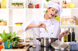 Young woman chef cooking in kitchen