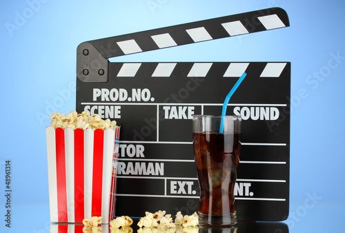 Photo: Movie clapperboard, cola and popcorn on blue background Movie clapperboard, cola and popcorn on blue background