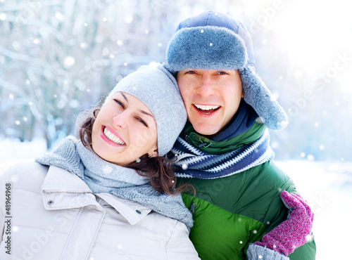 Photo: Happy Couple Having Fun Outdoors. Snow. Winter Vacation Happy Couple Having Fun Outdoors. Snow. Winter Vacation