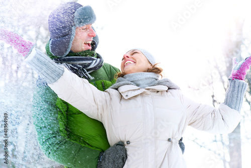 Photo: Happy Couple Having Fun Outdoors. Snow. Winter Vacation Happy Couple Having Fun Outdoors. Snow. Winter Vacation