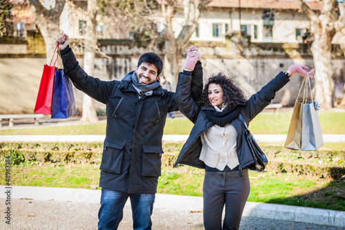 Photo: Happy Young Couple with Shopping Bags Happy Young Couple with Shopping Bags