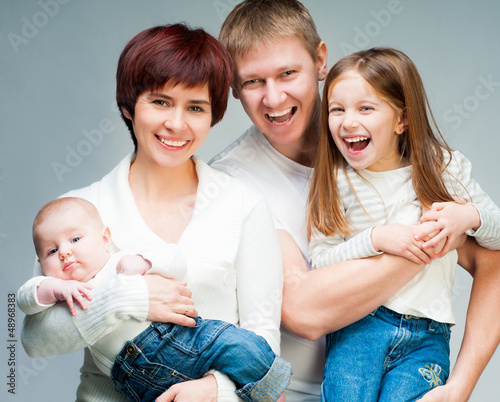 Photo: Pretty smiling family looking at the camera Pretty smiling family looking at the camera