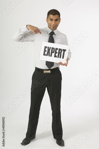 Photo: Man Holding A Sign That Says Expert Man Holding A Sign That Says Expert