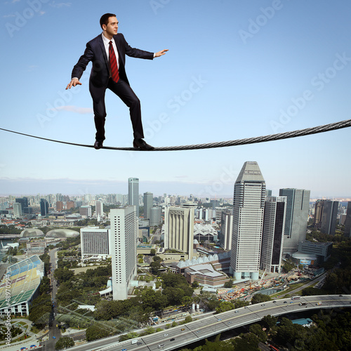 Photo: Balancing businessman and cityscape Balancing businessman and cityscape