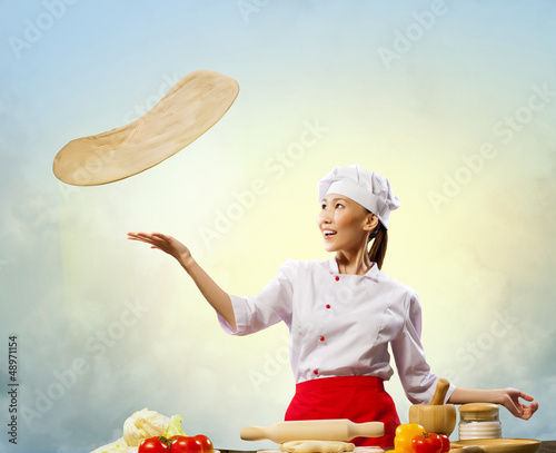 Photo: Asian female cook making pizza Asian female cook making pizza