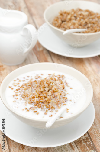 Photo: Boiled buckwheat with milk in a white bowl vertical Boiled buckwheat with milk in a white bowl vertical