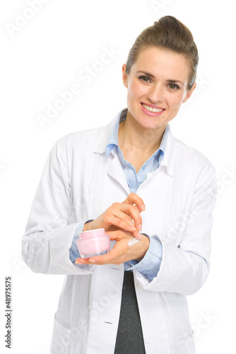 Photo: Smiling kosmetist woman applying creme on hand Smiling kosmetist woman applying creme on hand