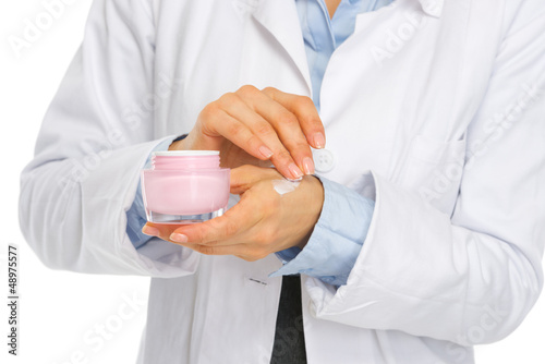 Photo: Closeup on kosmetist woman applying creme on hand Closeup on kosmetist woman applying creme on hand