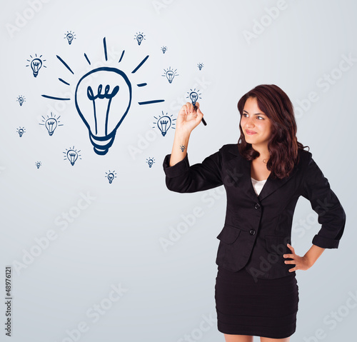 Photo: Woman drawing light bulb on whiteboard Woman drawing light bulb on whiteboard