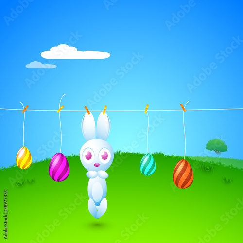 Vector: Hanging cute Easter Bunny and painted Easter Eggs in a rope on b Hanging cute Easter Bunny and painted Easter Eggs in a rope on b