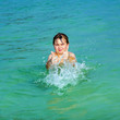 handsome boy has fun in the ocean and shows thumbs up