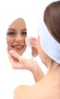 Young woman cleansing her face, isolated on white