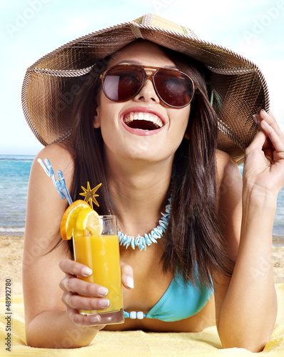 Photo: Girl in bikini on beach drinking cocktail. Girl in bikini on beach drinking cocktail.