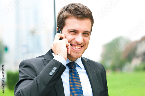 Photo: Portrait of a young businessman talking on the phone Portrait of a young businessman talking on the phone