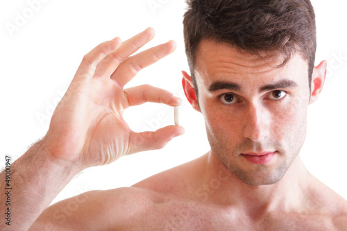 Photo: Closeup of handsome man holding pills Closeup of handsome man holding pills