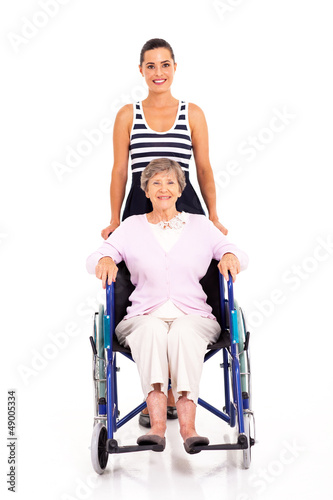 Photo: granddaughter pushing disabled senior grandmother on wheelchair granddaughter pushing disabled senior grandmother on wheelchair