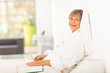 peaceful elderly woman reading book on bed