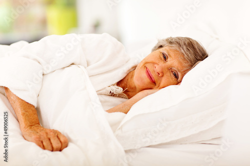 Photo: happy senior woman sleeping on bed happy senior woman sleeping on bed
