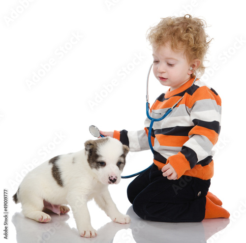 Photo: child examining dog and listening with stethoscope child examining dog and listening with stethoscope
