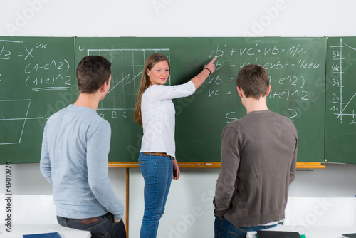 Photo: schülerin erklärt die aufgaben an der tafel schülerin erklärt die aufgaben an der tafel