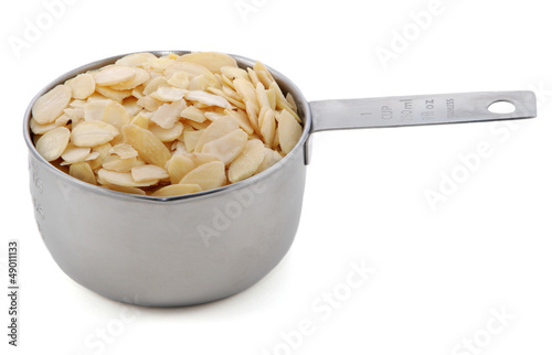 Photo: Flaked almonds presented in an American metal cup measure Flaked almonds presented in an American metal cup measure