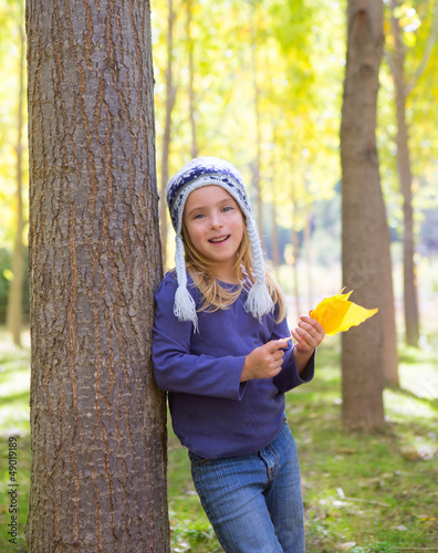 Photo: Child girl in autumn poplar forest yellow fall leaves in hand Child girl in autumn poplar forest yellow fall leaves in hand