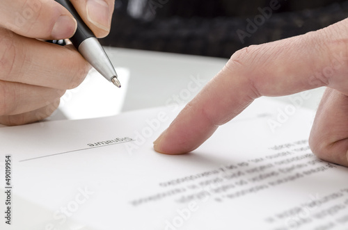 Photo: Woman signing a paper Woman signing a paper