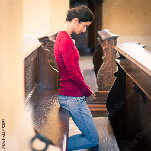Photo: Young woman praying in a church Young woman praying in a church