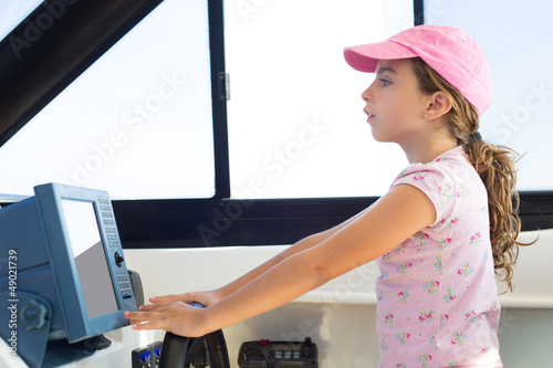 Photo: child girl sailing steering the boat wheel child girl sailing steering the boat wheel