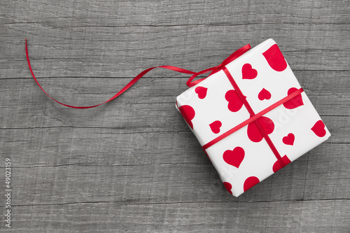 Photo: Ein Geschenk mit rot weißem Papier und Herzen zum Valentinstag Ein Geschenk mit rot weißem Papier und Herzen zum Valentinstag