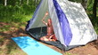 boy near camping tent in forest