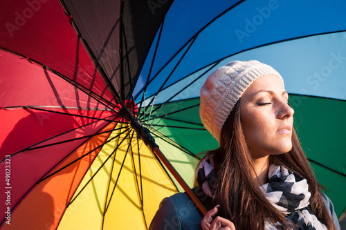 Photo: Young woman with multicolored umbrella. Young woman with multicolored umbrella.